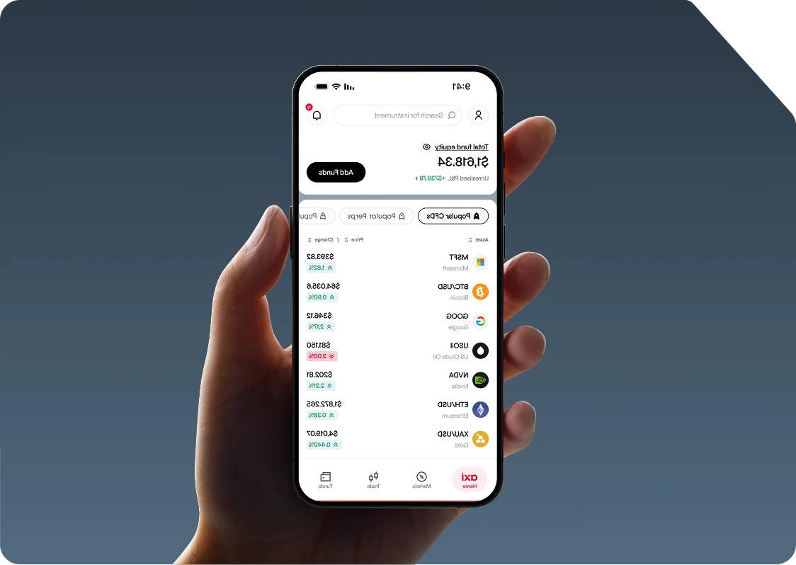 Hand holding a phone showing the Axi app with a Become a Pro Trader banner and a Top CFDs watchlist