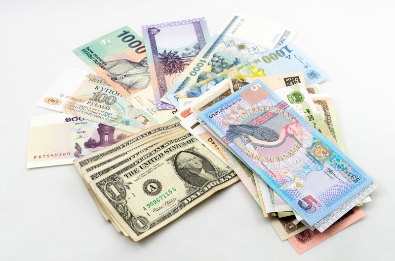 Different countries banknotes spread out flat on table