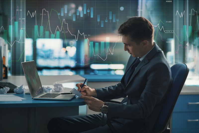 Trader writing notes down at their desk
