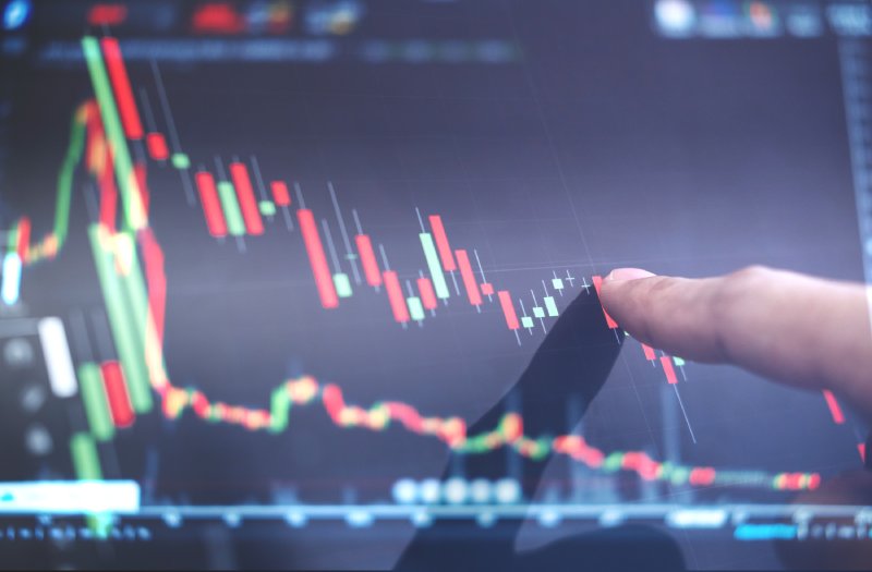 Finger pointing at a trading chart that is going down