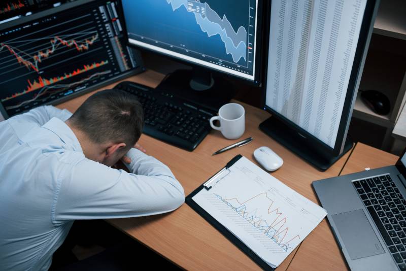 Trader looking emotional at their desk
